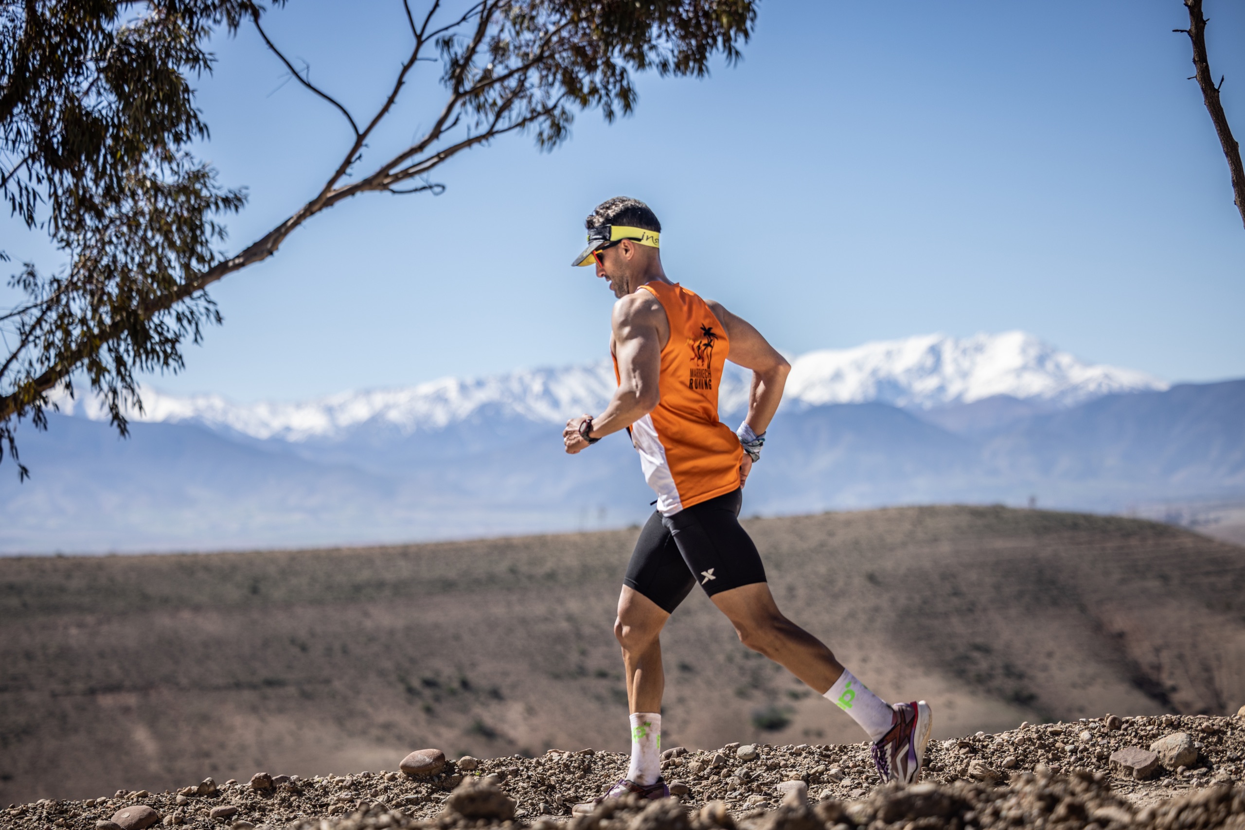 Coureur du Trail Takerkoust devant les montagnes du Haut Atlas