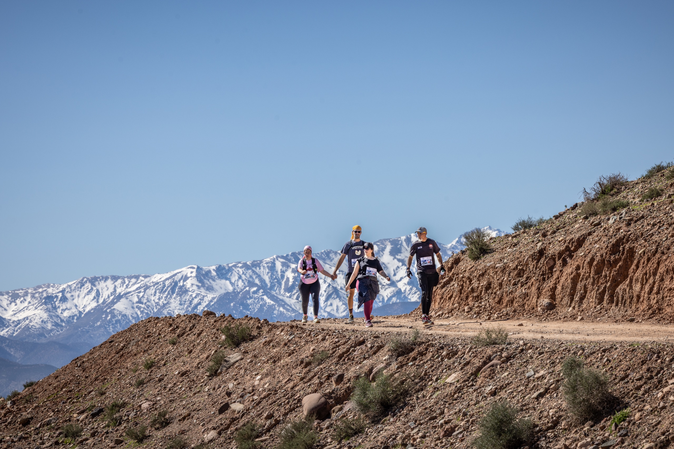 Groupe de participants au Trail Takerkoust sur une crête face au Haut Atlas