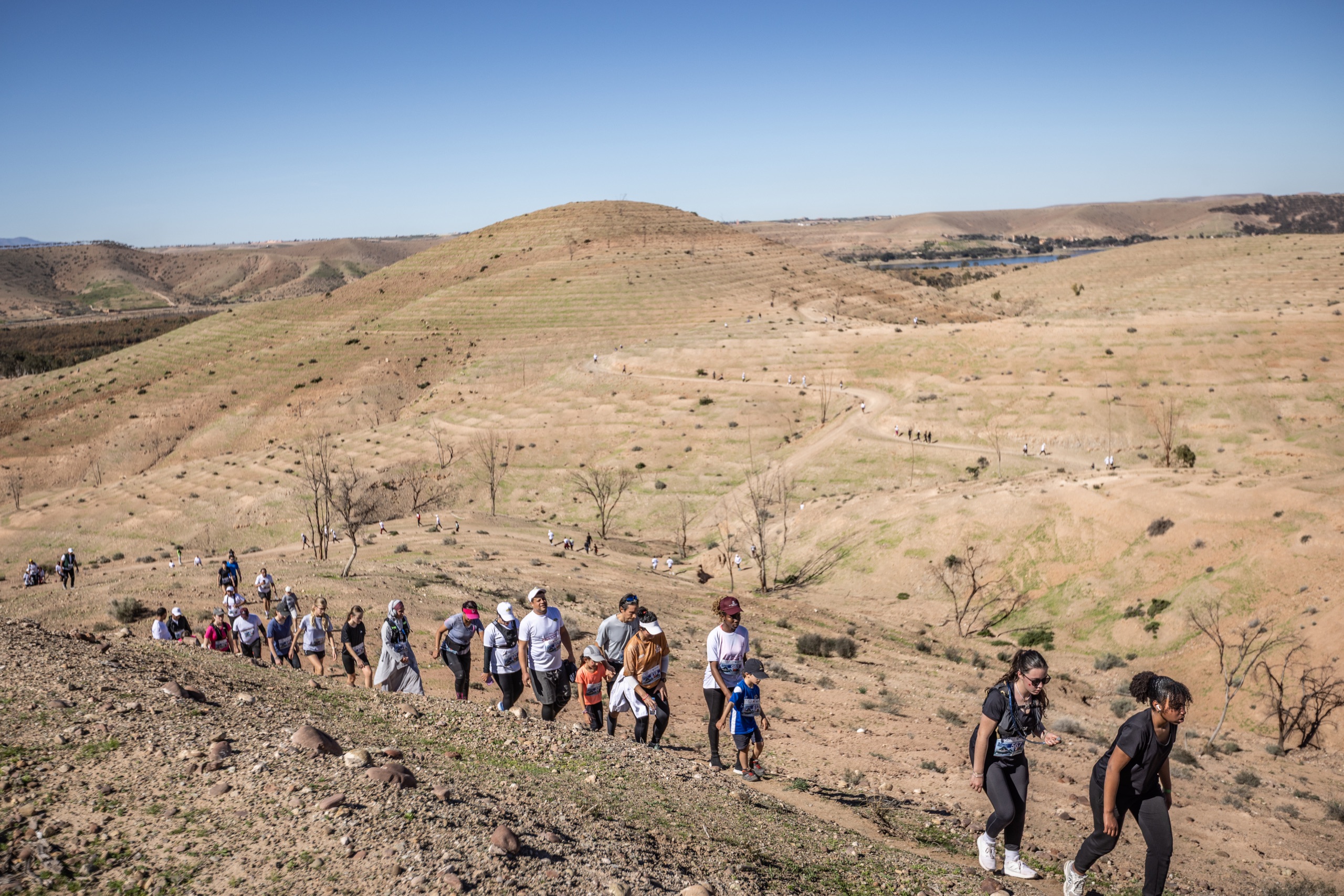 Peloton du Trail Takerkoust progressant dans le grand paysage près du lac